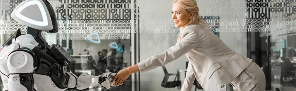 Panoramiczny Strzał Uśmiechnięta Bizneswoman Uścisk Dłoni Robotem Siedzi Przy Biurku — Zdjęcie stockowe