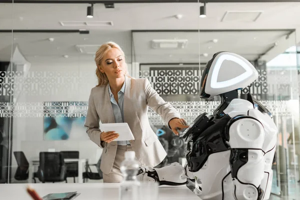 Attraktiv Forretningskvinne Som Holder Digital Nettbrett Mens Hun Driver Robot – stockfoto