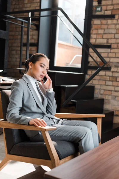Serious Asian Businesswoman Sitting Armchair Talking Smartphone — Stock Photo, Image