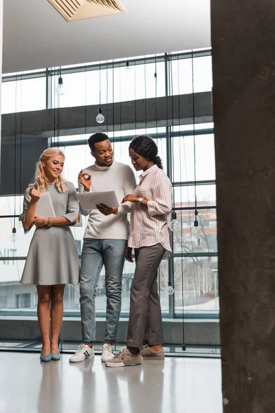 Young Multicultural Businesspeople Having Discussion While Standing Office Looking Documents — Stock Photo, Image