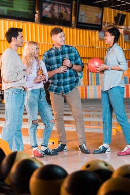 Bowling kulübünde konuşan neşeli, çok kültürlü arkadaşların seçici odağı.
