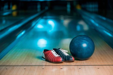 Bowling ayakkabılarının ve topun seçici odak noktası bowling kulübündeki Skittle sokağı.