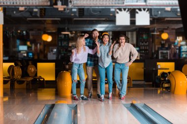 Bowling kulübünün Skittle sokağının yanında duran dört neşeli çok kültürlü arkadaş.