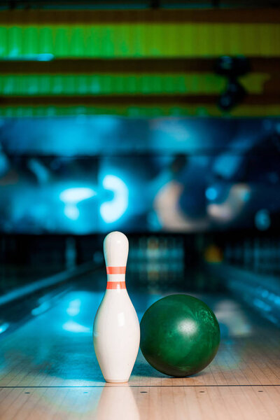 selective focus of bowling ball and skittle on bowling alley