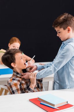Okuldaki zorba öğrencilerin seçici odak noktası siyahlar içinde izole edilmiş sınıf arkadaşları.