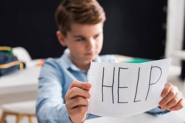 Seçici kağıt odağı, üzgün okul çocuğu ve zorbalık kavramının el yazısı.