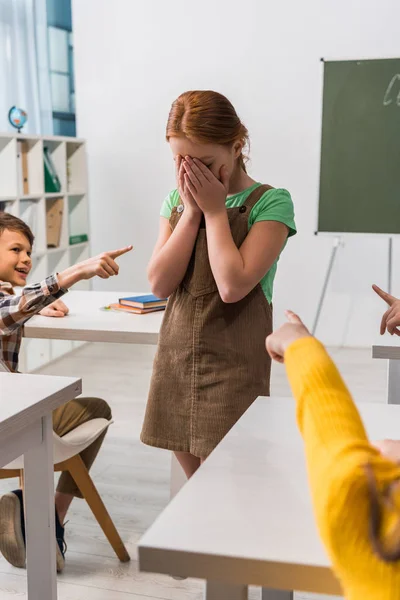 Selective Focus Cheerful Schoolboy Pointing Finger Frustrated Classmate Schoolkids Classroom — Stock Photo, Image