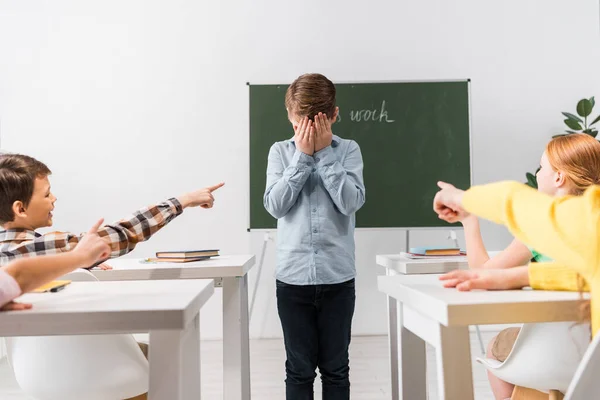 Selective Focus Classmates Pointing Fingers Frustrated Schoolboy Covering Face Bullying — Stock Photo, Image