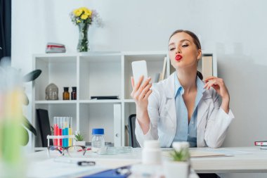 Klinikte selfie çekerken ördek suratlı seksi hemşirenin hava öpücüğü göndermesi. 