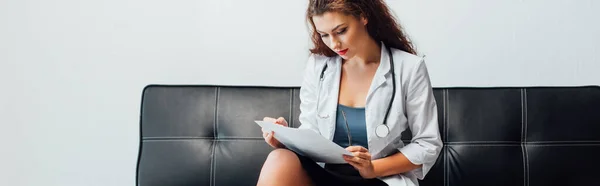 Panoramic Shot Sexy Nurse Looking Document Sitting Sofa — Stock Photo, Image