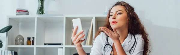 Tiro Panorâmico Encaracolado Sexy Enfermeira Enviando Beijo Tomar Selfie Clínica — Fotografia de Stock