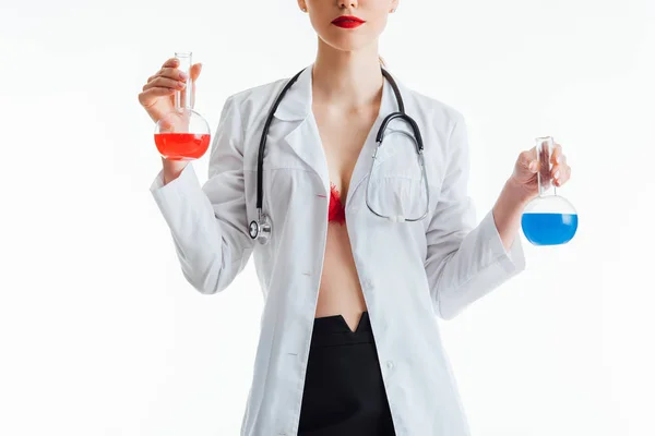 穿着白色外套的性感护士的剪影 她拿着红色和蓝色液体隔离在白色的瓶子里 — 图库照片