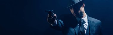Gangster nişan silahı koyu arka planda uzanmış, panoramik çekim