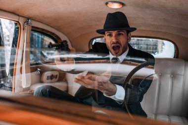 Gangsterlerin seçici odak noktası silah doğrultup arabada bağırmak.