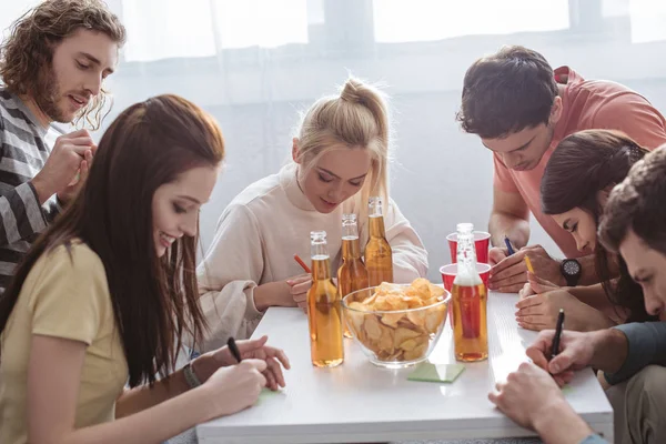 Curious Man Looking Girl Writing Sticky Note While Playing Name — Stock Photo, Image