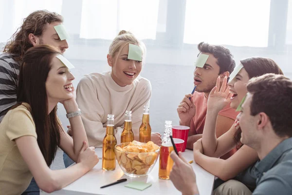 Smiling Friends Sticky Notes Foreheads Playing Name Game Table Drinks — Stock Photo, Image