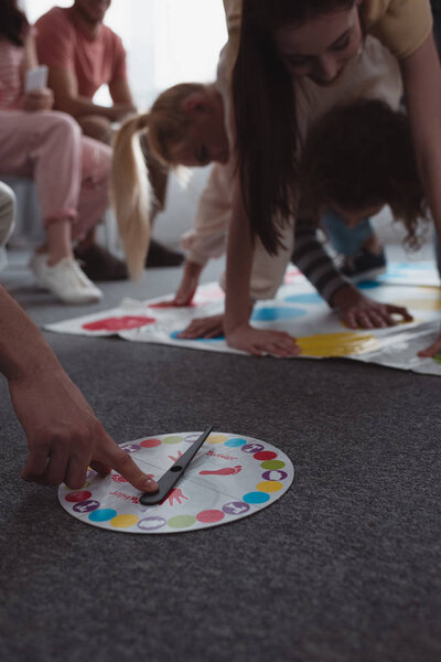 KYIV, UKRAINE - JANUARY 27, 2020: cropped view of man touching moves board while girls playing twister game