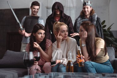Kızların konuştuğu, bira içtiği, şarap içtiği ve periler gibi giyinen erkeklerin arka planda durduğu seçici odak noktası.