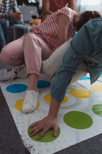KYIV, UKRAINE - JANUARY 27, 2020: cropped view of friends playing twister game at home
