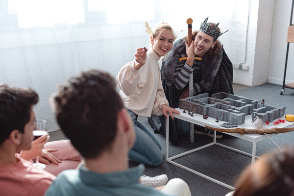 KYIV, UKRAINE - JANUARY 27, 2020: selective focus of man and woman in fairy costumes playing labyrinth game near friends 