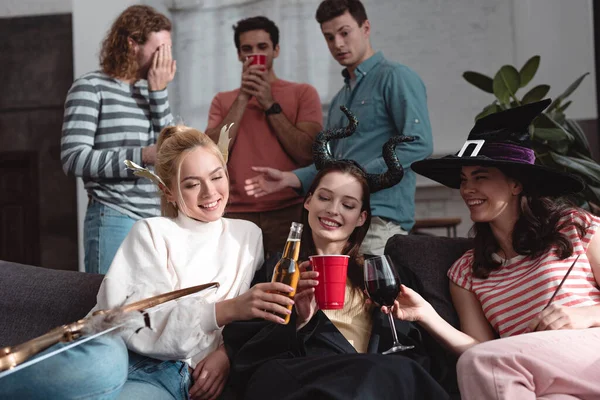 Pohlední Muži Stojící Poblíž Veselých Dívek Pijících Pivo Víno Limonádu — Stock fotografie