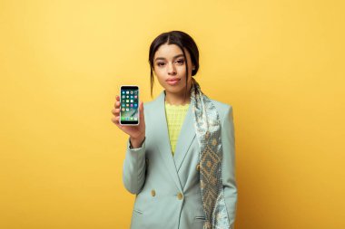 Kyiv, Ukrayna - 4 Şubat 2020: Sarıda iPhone tutan güzel Afrikalı Amerikalı kız 