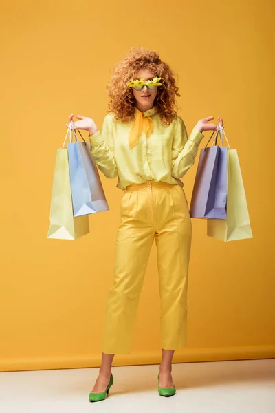Stylish Redhead Woman Sunglasses Flowers Holding Shopping Bags Yellow — Stock Photo, Image