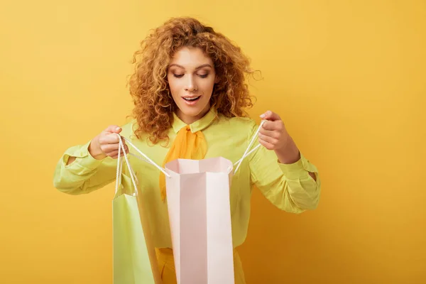 Excited Redhead Girl Looking Shopping Bag Yellow — Stock Photo, Image
