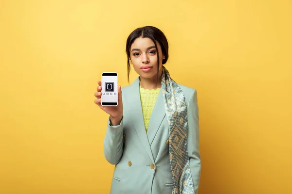 Kyiv ウクライナ 2020年2月4日 美しいアフリカ系アメリカ人の女の子を保持スマートフォン上の黄色の上にUberアプリ — ストック写真