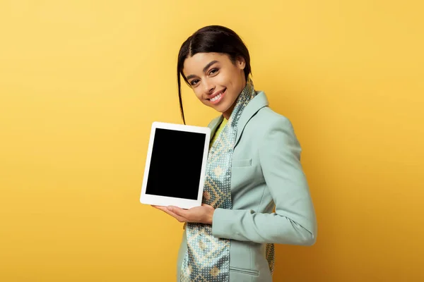 幸せなアフリカ系アメリカ人女性は黄色の上に空白の画面でデジタルタブレットを保持 — ストック写真