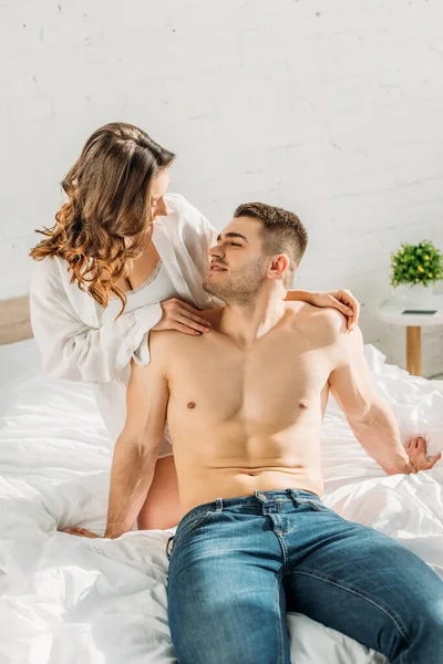 Сексуальная Девушка Белой Рубашке Трогает Плечи Улыбающегося Рубашки Мужчины Сидящего — стоковое фото