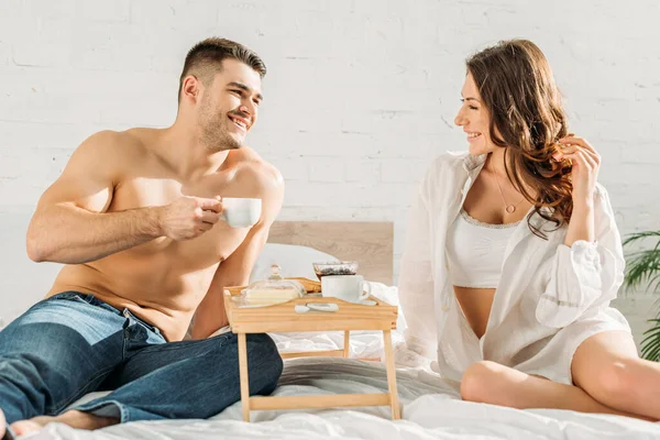 Smiling Shirtless Man Holding Cup Coffee Looking Sexy Girlfriend Bed — Stock Photo, Image