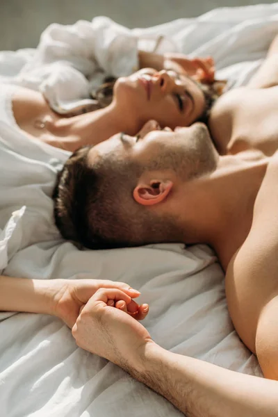 Selective Focus Happy Young Couple Holding Hands While Lying Bed — Stock Photo, Image