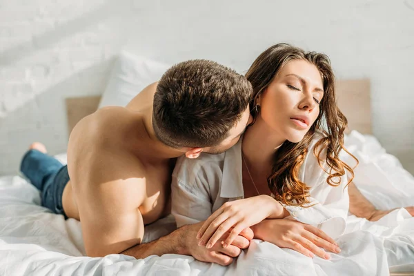 Young Shirtless Man Kissing Passionate Girlfriend Lying Bed Closed Eyes — Stock Photo, Image