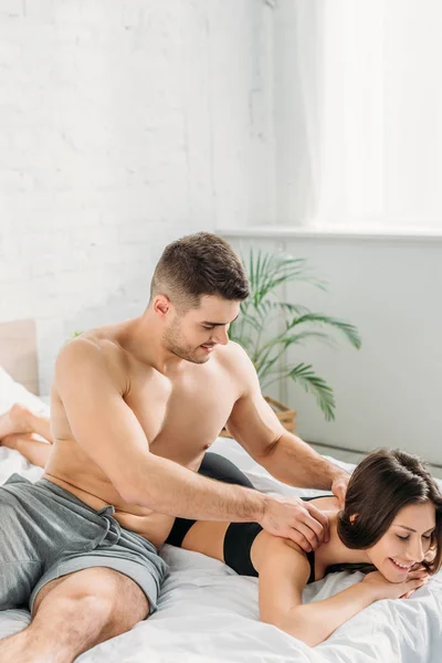 Sexy Shirtless Man Making Shoulders Erotic Massage Girlfriend Lying Smiling — Stock Photo, Image