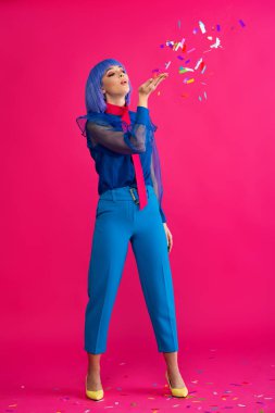 Mor peruklu güzel pop sanatçısı kız pembe konfeti üflüyor.