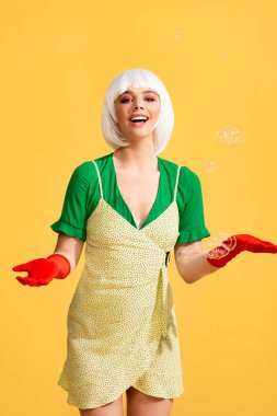 Beyaz peruklu, sabun köpüklü, sarı renkli çekici, mutlu pop sanatçısı kız. 