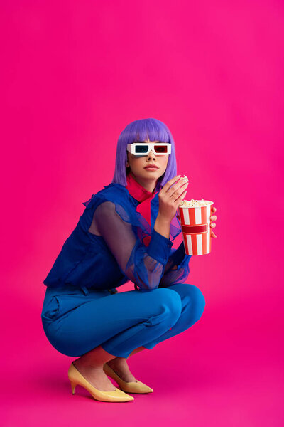 attractive pop art girl in purple wig and 3d glasses eating popcorn, on pink