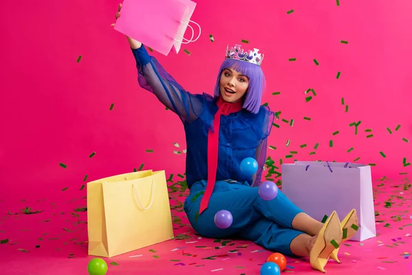 Возбужденная Девушка Фиолетовом Парике Короне Сидя Пакетами Покупок Шариками Праздничными — стоковое фото