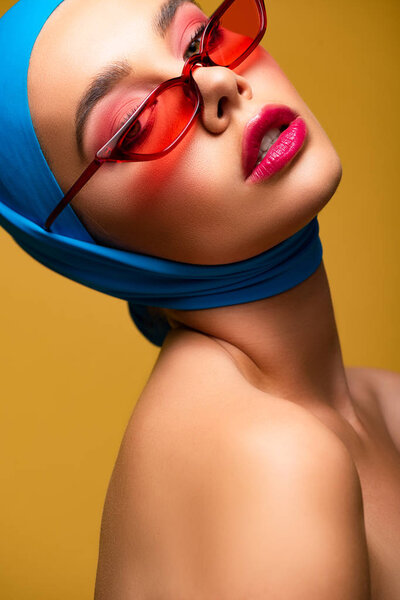 beautiful sexy girl in trendy scarf and red sunglasses, isolated on yellow