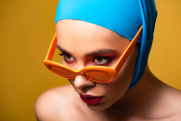 naked woman in scarf and trendy sunglasses, isolated on yellow