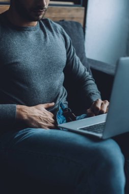 Dizüstü bilgisayarda mastürbasyon yapan ve porno izleyen genç bir adam. 