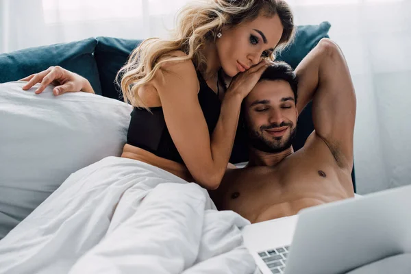 Attractive Woman Touching Smiling Man While Looking Laptop Bed — ストック写真