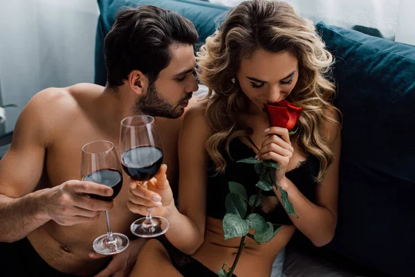 美しいです女性香りローズとトースト赤ワインとともにボーイフレンドオンベッド — ストック写真