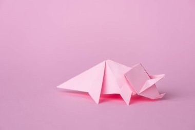Pembe üzerine küçük origami gergedanları ve kopyalama alanı 