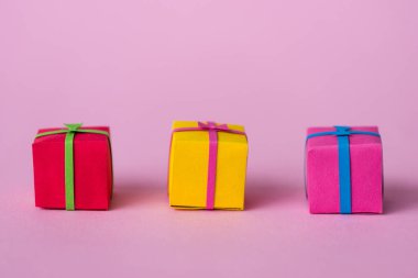 colorful and small paper gift boxes on pink  clipart