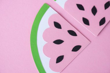 Dilimlenmiş kağıt karpuzun üst görüntüsü. Pembe üzerine izole edilmiş siyah tohumlar. 