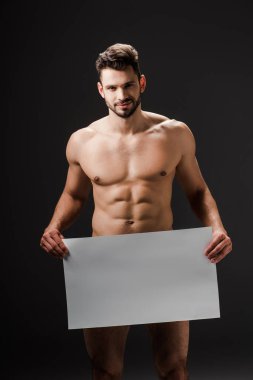 Siyah üzerinde boş pankart tutan mutlu, seksi, çıplak bir adam.