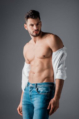 Beyaz gömlekli esmer, seksi adam ve gri pantolonlu.
