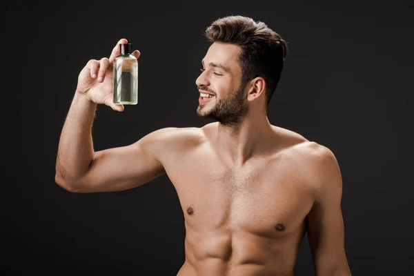 Sexy Glimlachen Naakt Man Holding Fles Van Cologne Geïsoleerd Zwart — Stockfoto